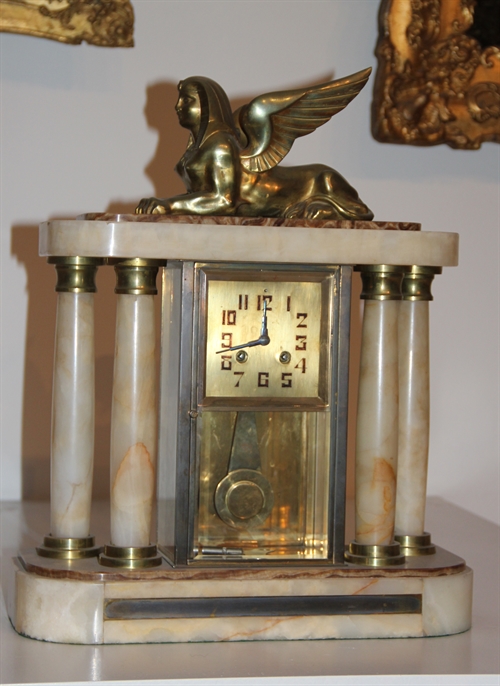 Standing clock with pillars and the lying sphinx on top